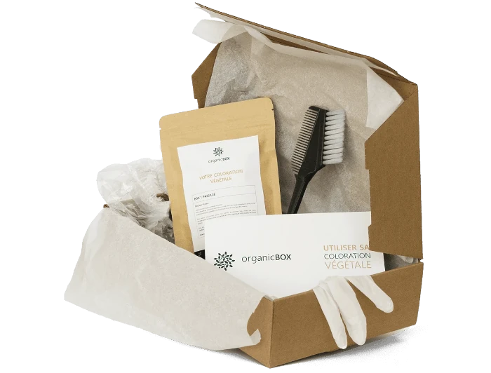 Aperçu de ce que contient la box de coloration végétale OrganicBox : poudre de couleur, pinceau, charlotte, gants, et un guide d'utilisation.